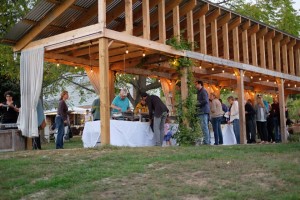Guests serve themselves under a structure built for farm dinners